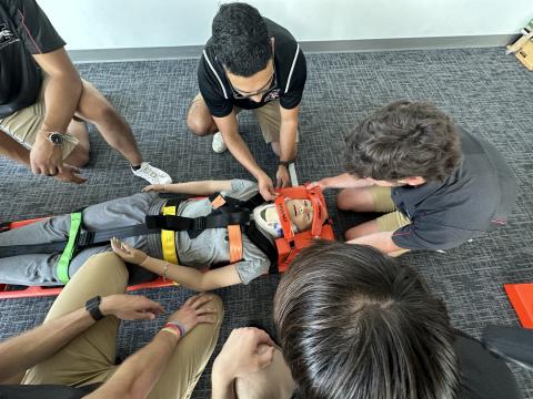 MAT students learning helmet removal techniques.